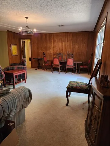 a living room with furniture a flat screen tv and a large window