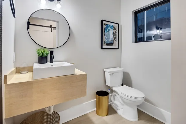 a bathroom with a toilet sink and mirror