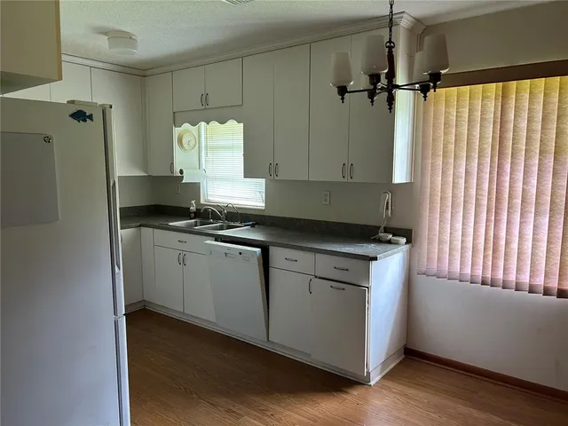 a kitchen with granite countertop white cabinets and white appliances