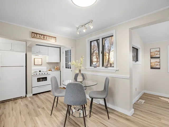a view of a dining room with furniture a rug and wooden floor