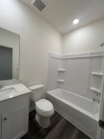 a spacious bathroom with a double vanity sink toilet and a tub