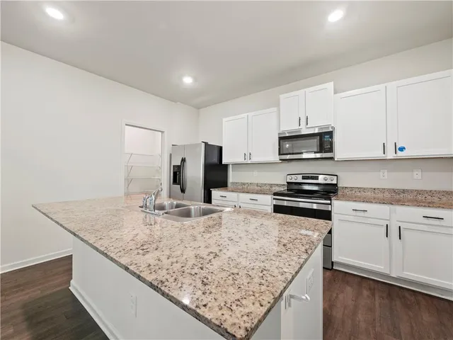 a kitchen with stainless steel appliances granite countertop a sink stove and refrigerator
