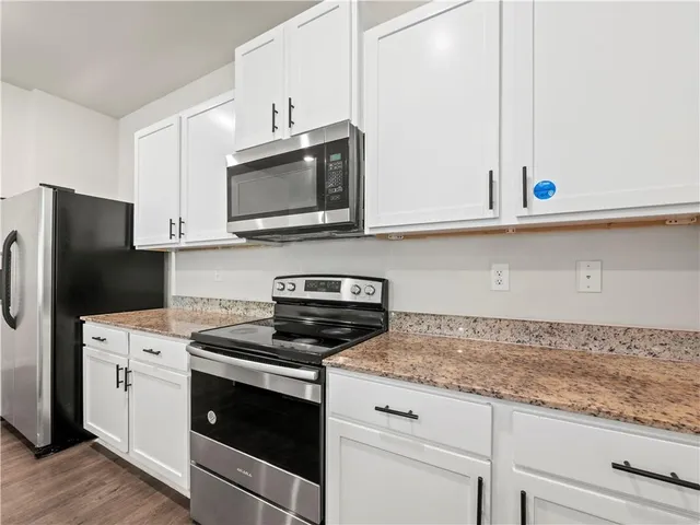 a kitchen with granite countertop cabinets stainless steel appliances and a counter space