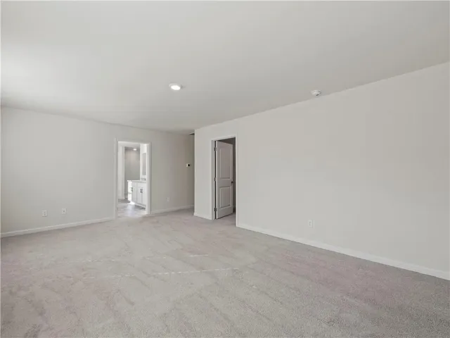a view of an empty room with closet and a window