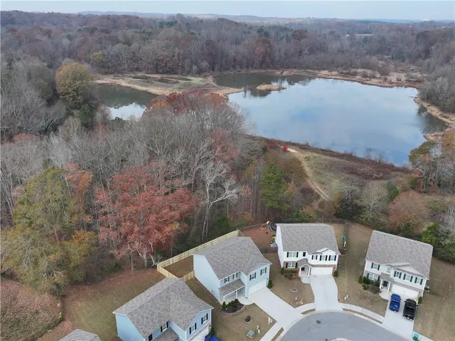 an aerial view of a house with yard and lake view