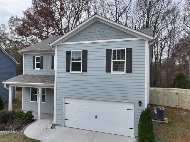 a view of a house with a yard and potted plants