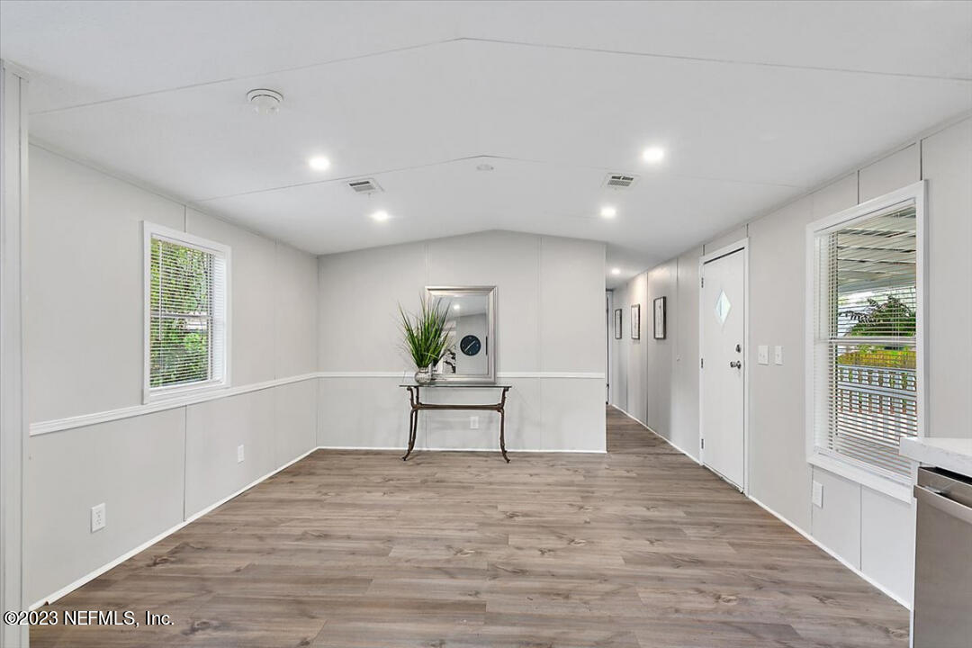 13712 Coman Road Jacksonville, FL 32218 - Photo 7 of 16 a view of empty room with wooden floor and window