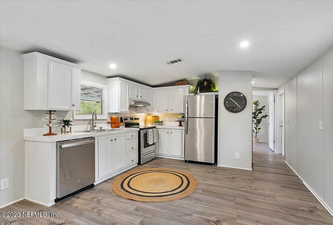 13712 Coman Road Jacksonville, FL 32218 - Photo 8 of 16 a kitchen with a refrigerator a stove and wooden cabinets