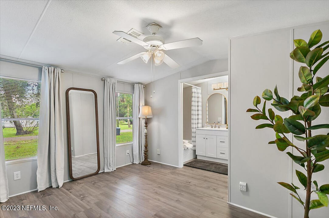 13712 Coman Road Jacksonville, FL 32218 - Photo 10 of 16 a view of an empty room with a window and wooden floor