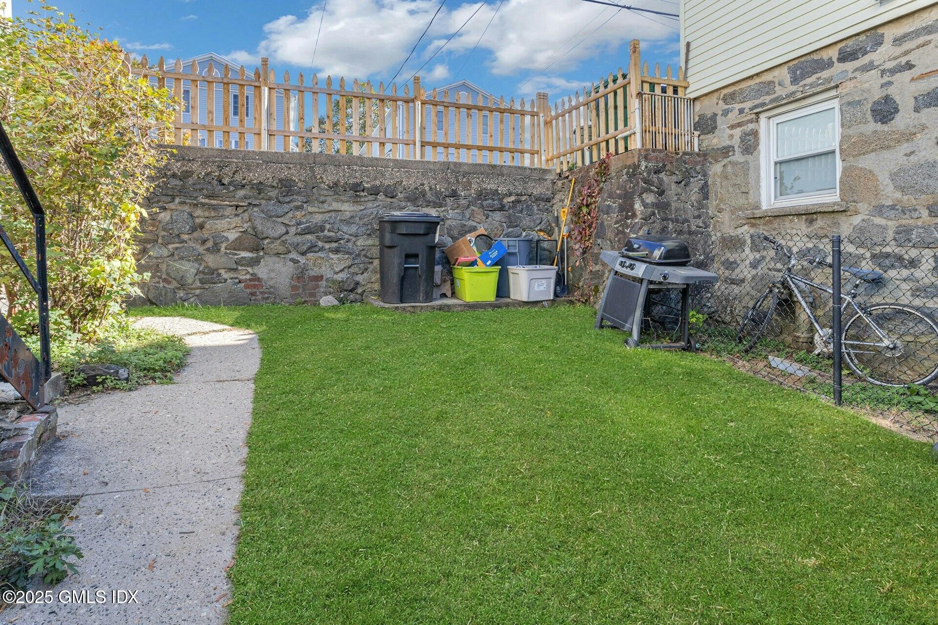 38 Alexander Street Greenwich, CT 06830 - Photo 28 of 36 a view of a chair and table in backyard of the house