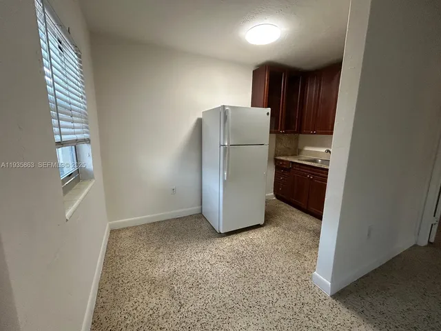 a view of kitchen with refrigerator and window