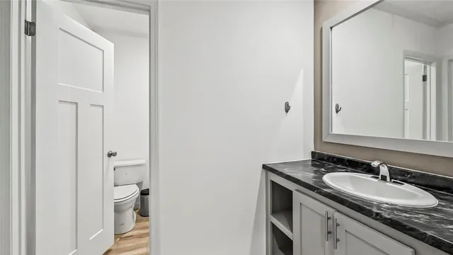 a bathroom with a granite countertop sink and a mirror
