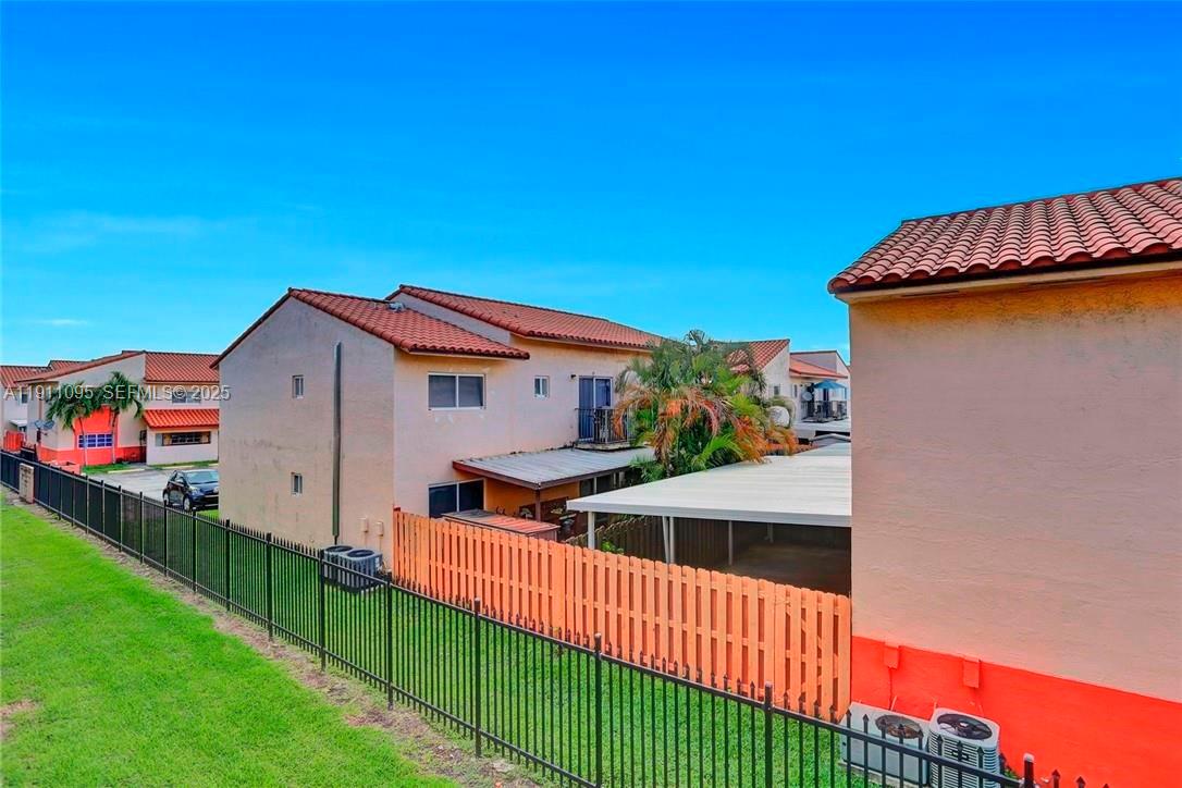 7755 West 30th Court, Unit E210 Hialeah, FL 33018 - Photo 13 of 14 a view of a house with wooden fence