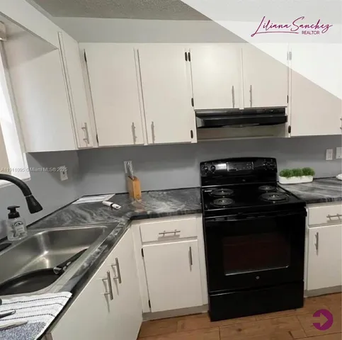 a kitchen with a sink stove and cabinets