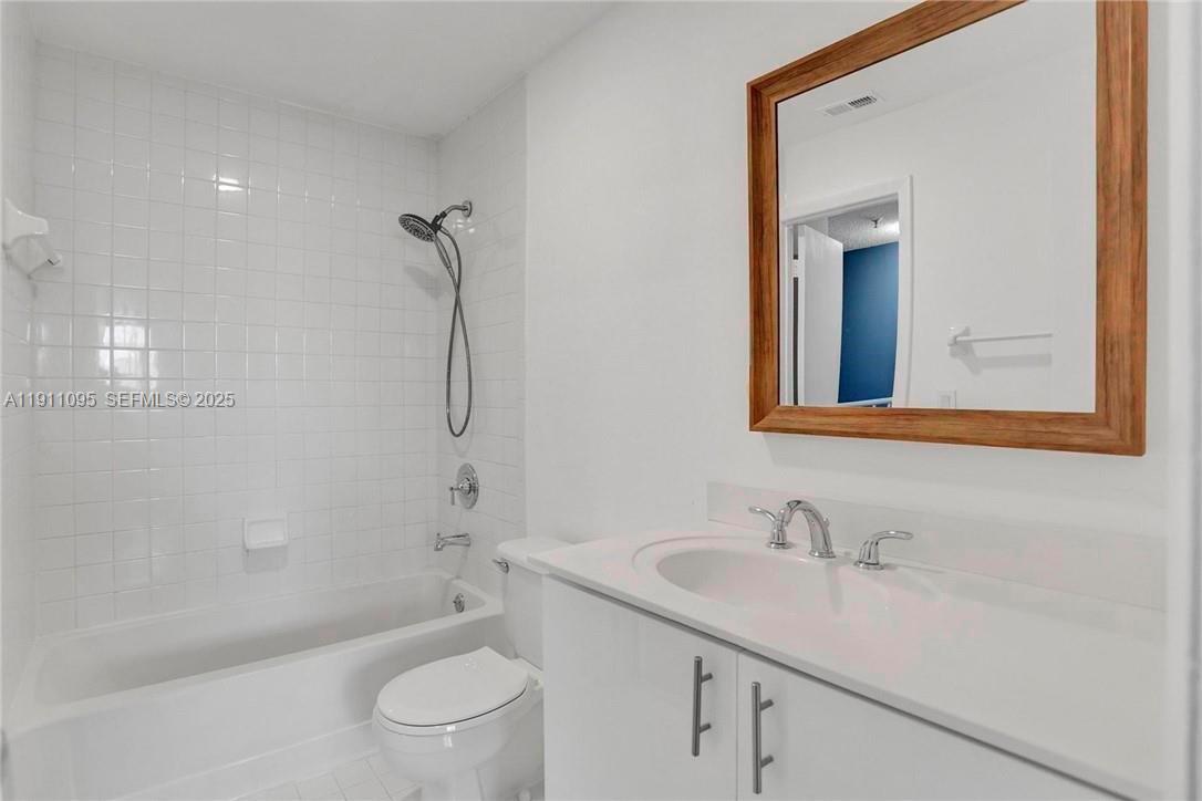 7755 West 30th Court, Unit E210 Hialeah, FL 33018 - Photo 10 of 14 a bathroom with a sink a toilet and shower