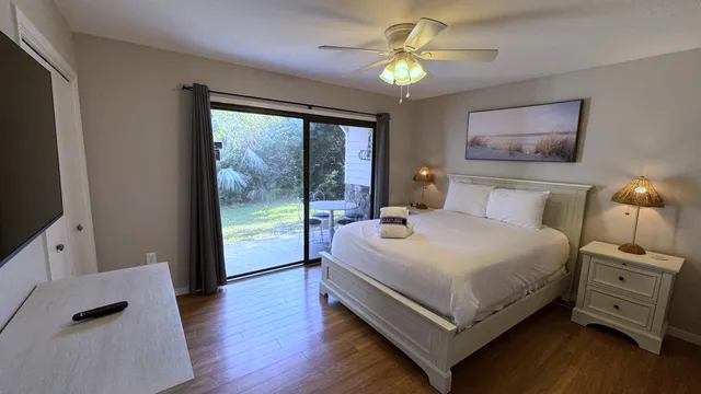 a bedroom with a bed and a flat tv screen on dresser