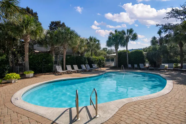 a view of a swimming pool with a patio and dining space