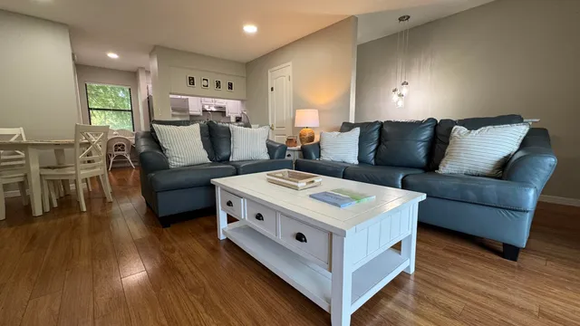 a living room with furniture and a wooden floor