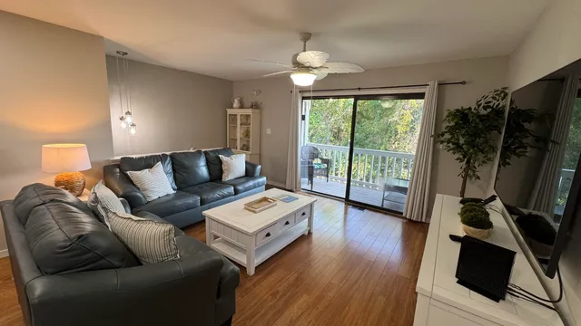 a living room with furniture a flat screen tv and a large window