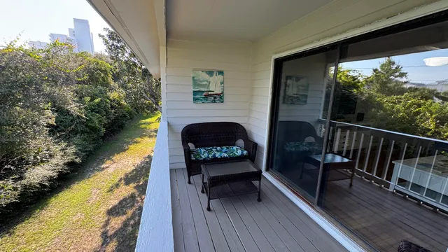 a view of a balcony with chairs and wooden floor