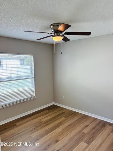 a view of a room with wooden floor and a window