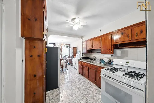a kitchen with stainless steel appliances granite countertop a refrigerator a stove and a sink with dishwasher