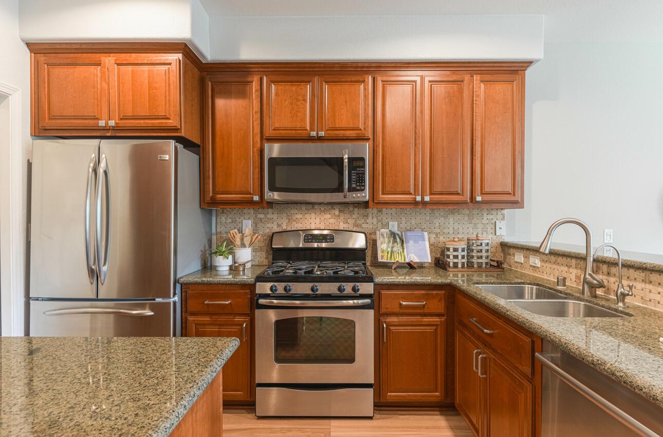 145 Atherton Loop Aptos, CA 95003 - Photo 13 of 47 a kitchen with granite countertop a refrigerator stove and microwave