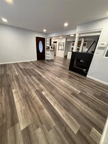 a kitchen with stainless steel appliances granite countertop a refrigerator oven a sink dishwasher and white cabinets with wooden floor