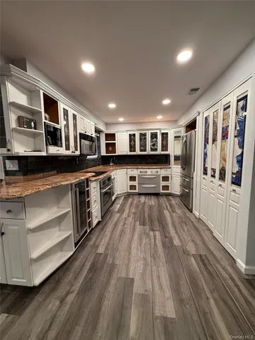 a large kitchen with stainless steel appliances granite countertop a stove and a microwave