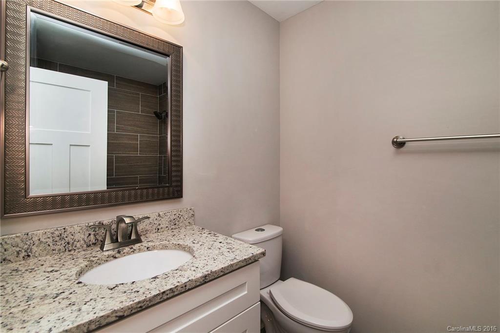 4209 Woodleaf Road Charlotte, NC 28205 - Photo 15 of 18 a bathroom with a granite countertop toilet sink and mirror