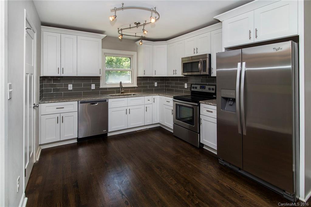 4209 Woodleaf Road Charlotte, NC 28205 - Photo 6 of 18 a kitchen with stainless steel appliances granite countertop a refrigerator a stove a sink dishwasher and a microwave oven with wooden floor