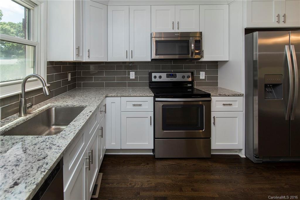 4209 Woodleaf Road Charlotte, NC 28205 - Photo 7 of 18 a kitchen with stainless steel appliances granite countertop a stove a microwave and a sink