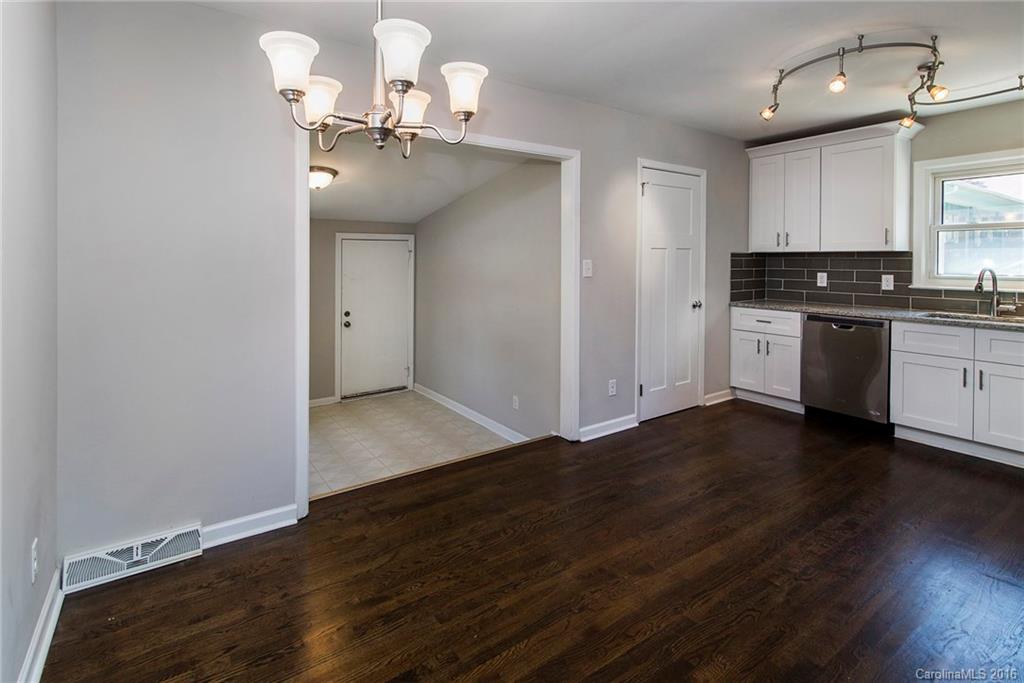 4209 Woodleaf Road Charlotte, NC 28205 - Photo 8 of 18 a view of a kitchen with a sink and dishwasher with wooden floor