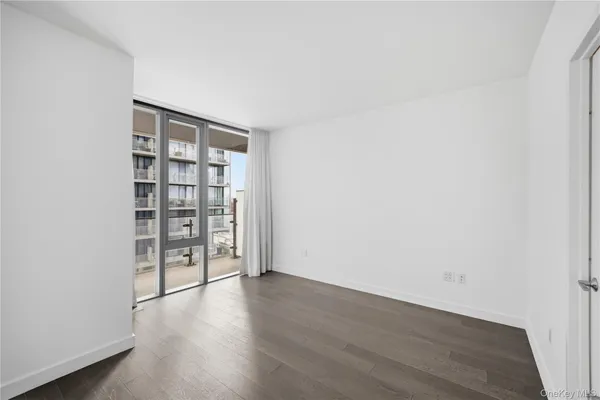 an empty room with wooden floor and cabinet