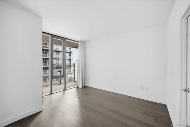an empty room with wooden floor and cabinet