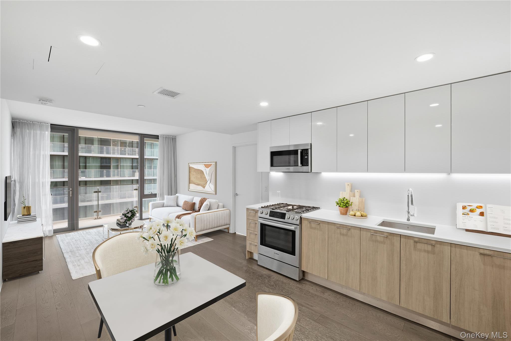 131-03 40 Road, Unit 11Q Queens, NY 11354 - Photo 4 of 31 a living room with furniture a rug kitchen view and a window