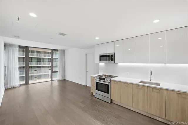 a view of kitchen with wooden floor and electronic appliances