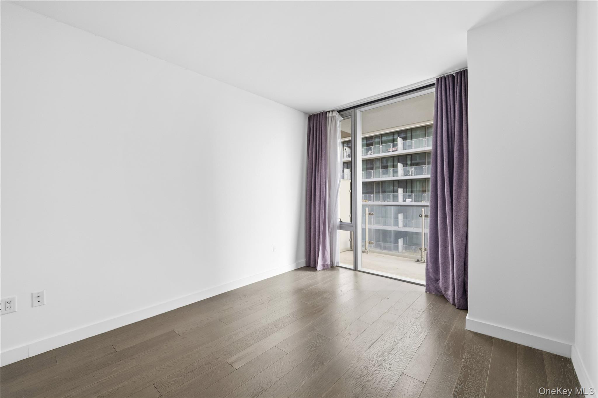 131-03 40 Road, Unit 11Q Queens, NY 11354 - Photo 8 of 31 a view of wooden floor and windows in a room