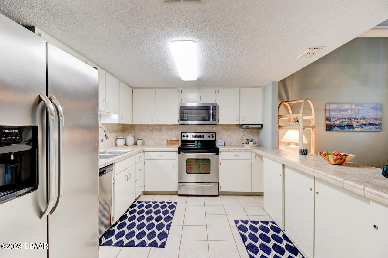 13 Glen Arbor Park Ormond Beach, FL 32174 - Photo 11 of 35 a kitchen with stainless steel appliances granite countertop a refrigerator and a stove top oven