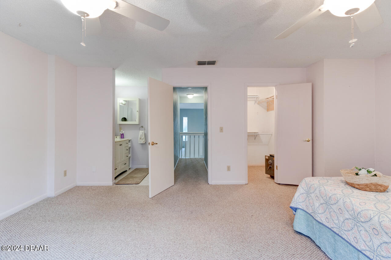 13 Glen Arbor Park Ormond Beach, FL 32174 - Photo 17 of 35 a spacious bedroom with a bed and cabinets