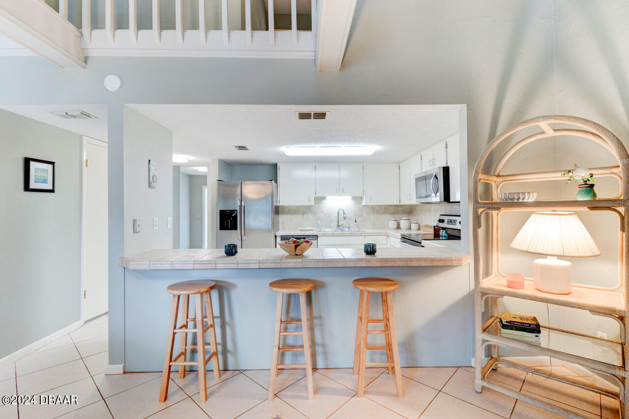 13 Glen Arbor Park Ormond Beach, FL 32174 - Photo 10 of 35 a kitchen with stainless steel appliances granite countertop a sink and cabinets