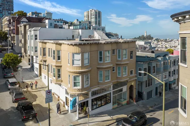 a front view of a building with streets and trees