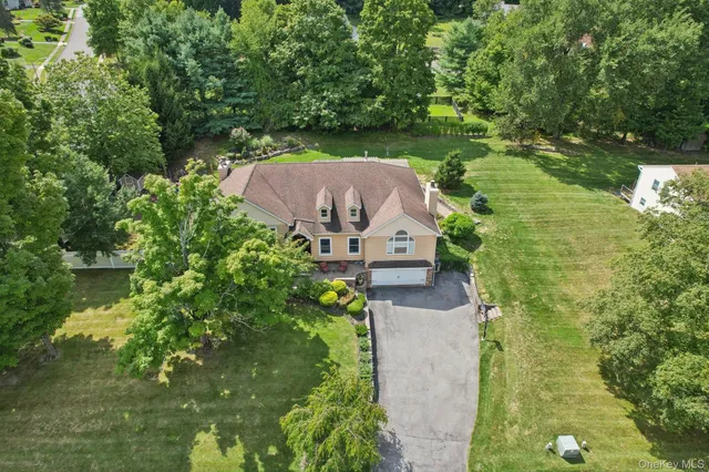an aerial view of a house with a yard basket ball court and outdoor seating