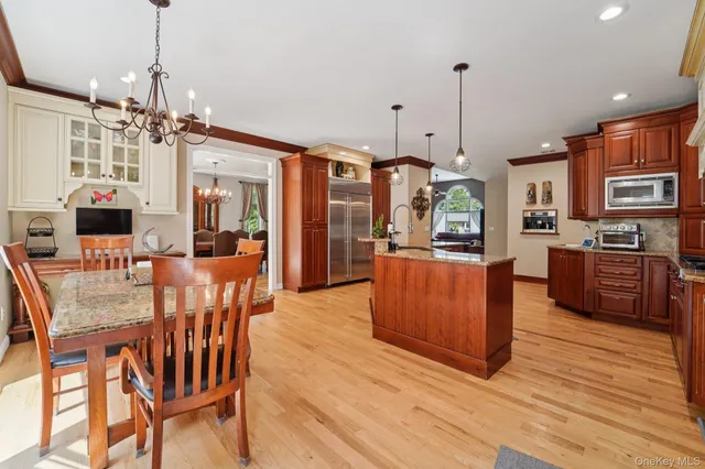 a view of a dining room and livingroom with furniture wooden floor a chandelier