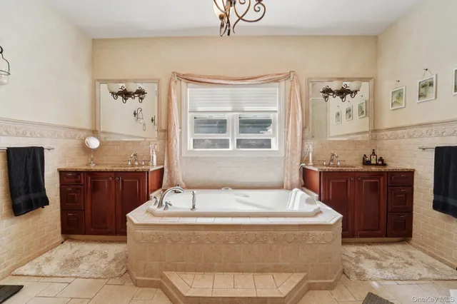 a spacious bathroom with a tub sink and mirror