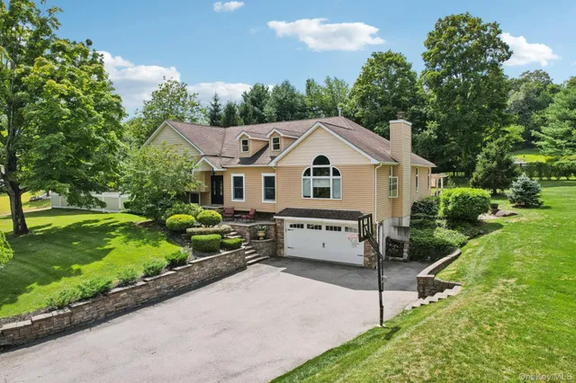 a front view of a house with a yard and potted plants