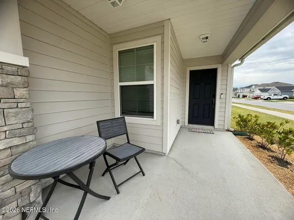a view of a porch with furniture and a yard