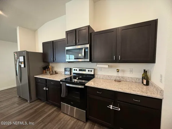 a kitchen with stainless steel appliances granite countertop a refrigerator stove and sink