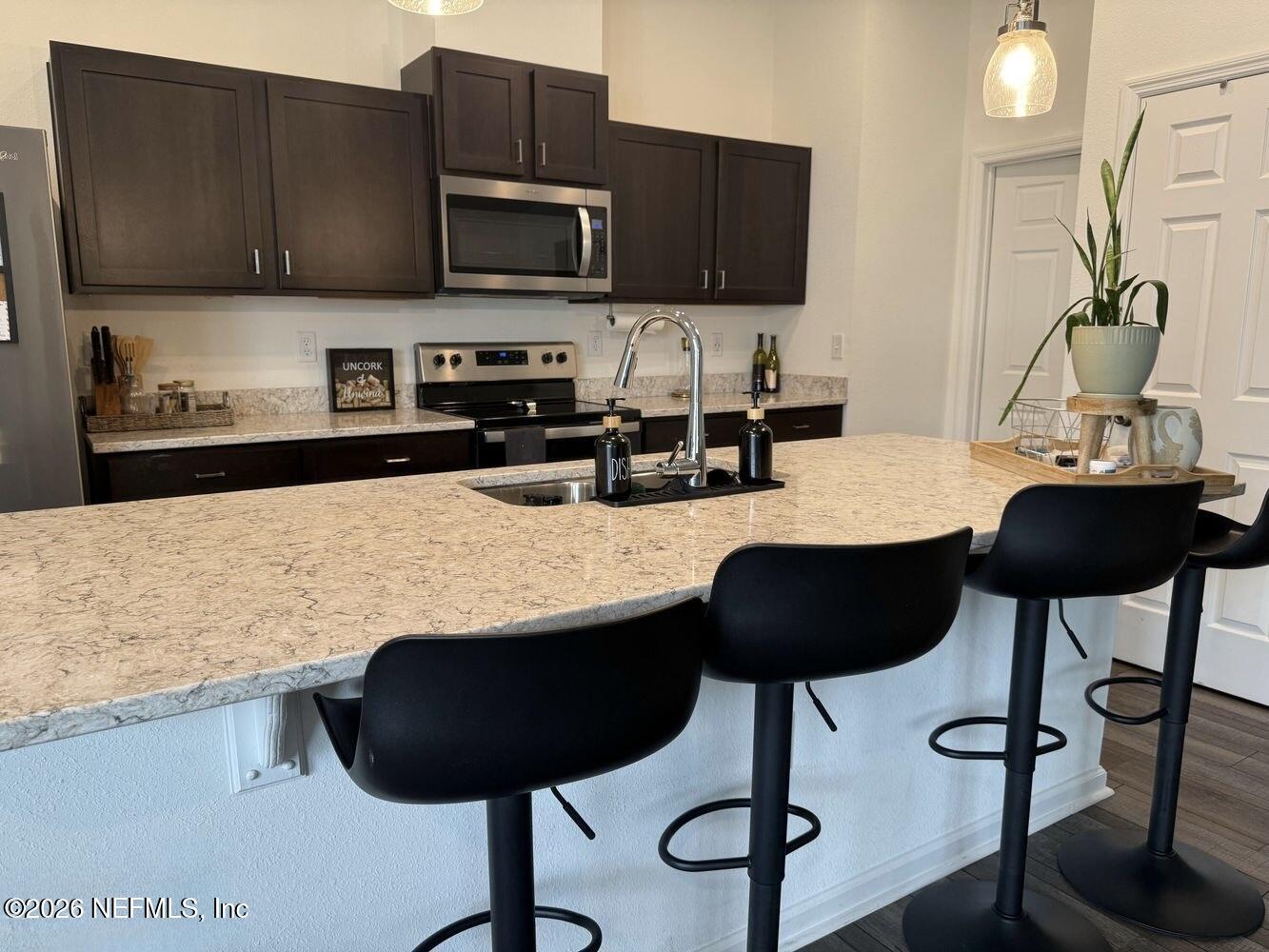 8161 Lumber Way Jacksonville, FL 32222 - Photo 6 of 13 a kitchen with granite countertop a stove a sink and a microwave