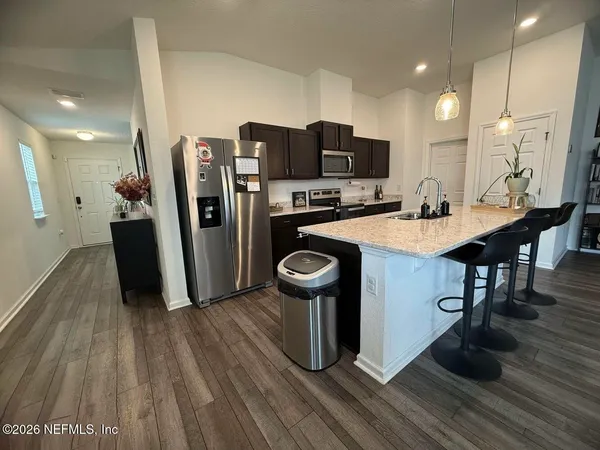 a kitchen with stainless steel appliances a kitchen island hardwood floor sink stove and refrigerator